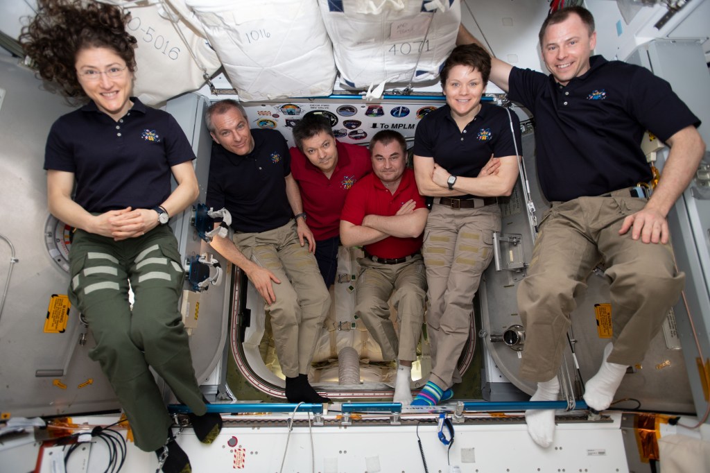The six-member Expedition 59 crew gathers for a portrait inside of the vestibule between the SpaceX Dragon cargo craft and the Harmony module. The hatch to Dragon was later closed and the resupply ship detached from Harmony before it was released from the grips of the Canadarm2 robotic arm. Dragon spent nearly a month attached to the International Space Station. From left are, astronauts Christina Koch of NASA and David Saint-Jacques of the Canadian Space Agency; Commander Oleg Kononenko and Flight Engineer Alexey Ovchinin of Roscosmos; and NASA astronauts Anne McClain and Nick Hague.
