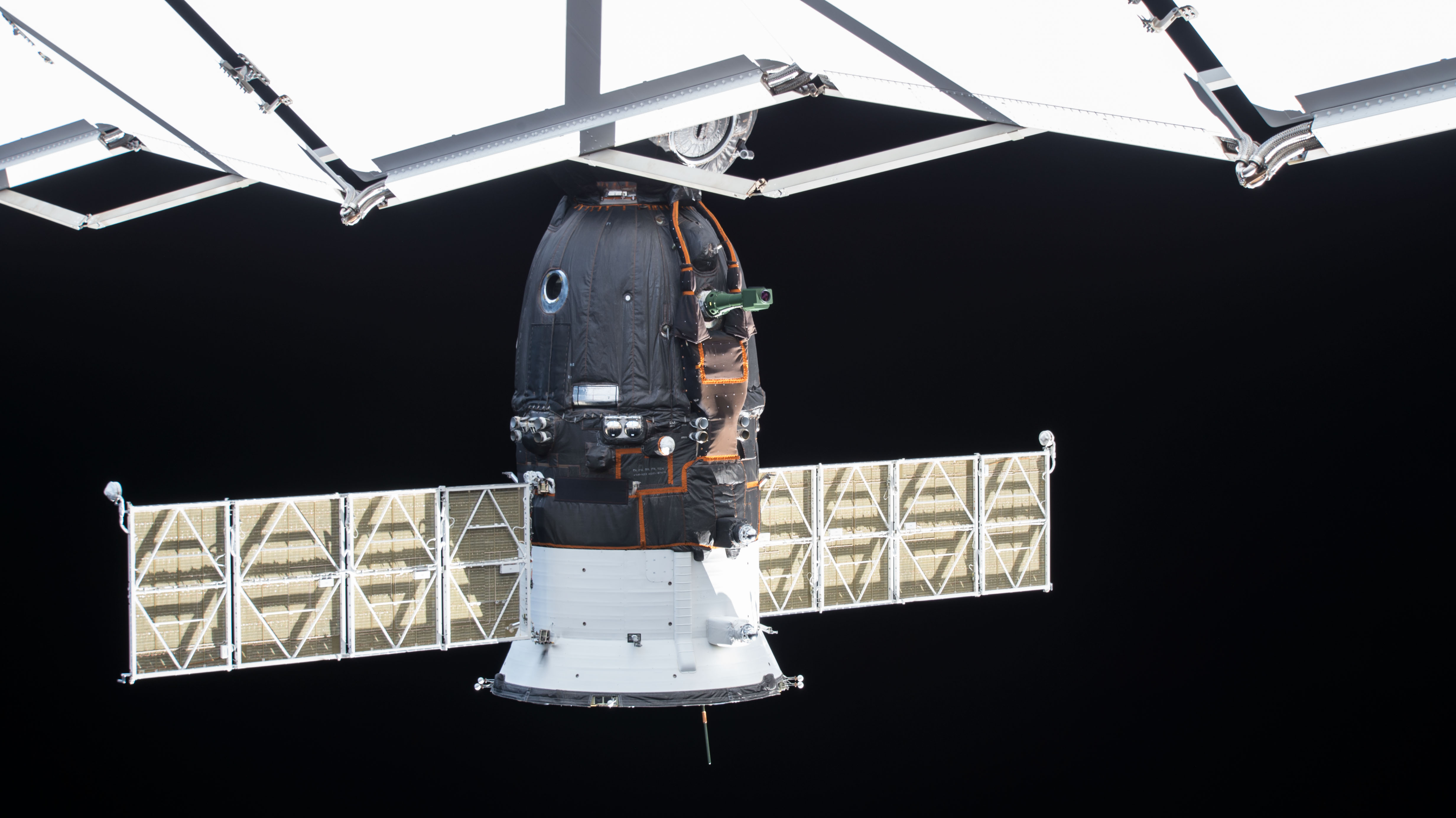 The Soyuz MS-11 spacecraft docked to the Poisk module is pictured from a ground-controlled external high definition camera. The Soyuz crew ship arrived at the International Space Station Dec. 3 with three new crewmembers, including Soyuz Commander Oleg Kononenko and Flight Engineers Anne McClain and David Saint-Jacques. It will return the same three crewmembers to a parachute-assisted landing in Kazakhstan on June 24.