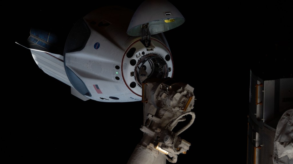 Astronauts Doug Hurley and Bob Behnken of NASA's Commercial Crew Program were aboard the SpaceX Crew Dragon as it approached the International Space Station. The Crew Dragon's nose cone is open revealing the spacecraft's docking mechanism that would connect to the Harmony module's forward International Docking Adapter.