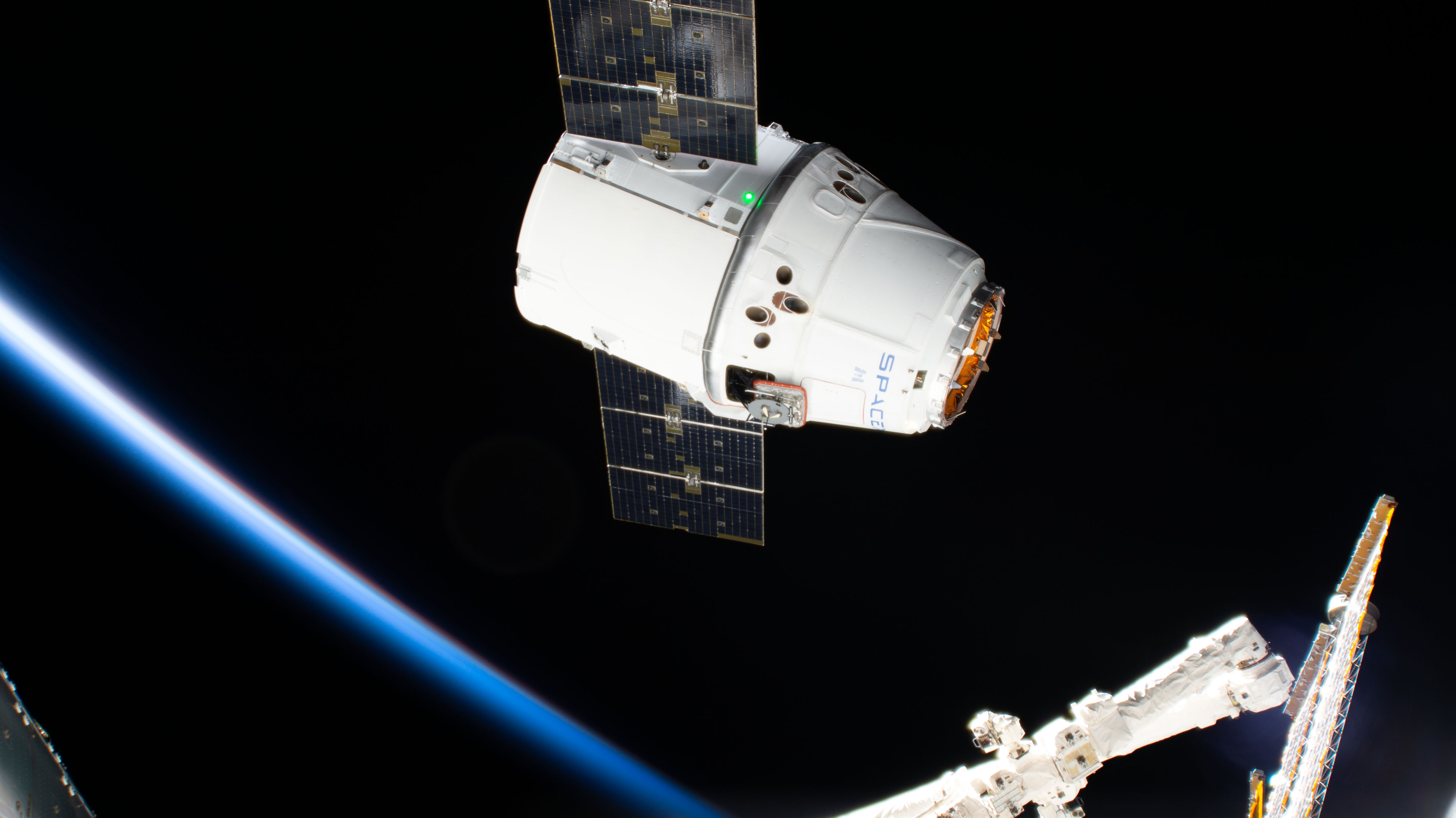 The SpaceX Dragon cargo craft approaches its capture point 10 meters from the International Space Station with the Canadarm2 robotic arm poised to reach out and grapple the resupply ship. Astronaut David Saint-Jacques would command the Canadarm2 to capture Dragon as astronaut Nick Hague backed him up and monitored systems.