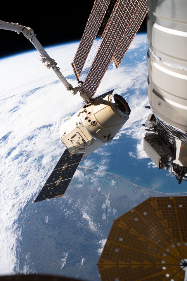 The SpaceX Dragon cargo craft on its 17th contracted mission to resupply mission to the International Space Station is pictured moments before being released from the Canadarm2 robotic arm. The orbiting lab was flying 261 miles above the Atlantic coast of South America.