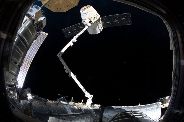 The SpaceX Dragon cargo craft on its 17th contracted mission to resupply mission to the International Space Station is in the grips of the Canadarm2 robotic arm moments before being released.