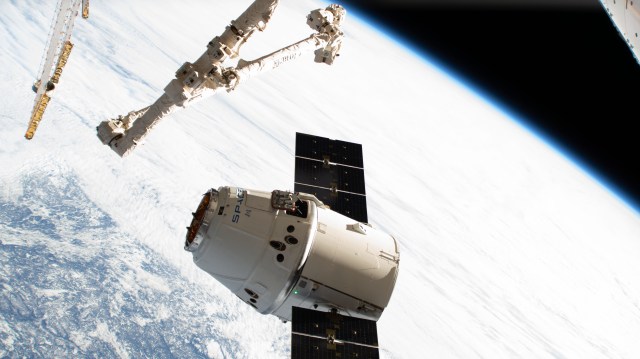 The SpaceX Dragon cargo craft reaches its capture point 10 meters from the International Space Station with the Canadarm2 robotic arm poised to reach out and grapple the resupply ship. Astronaut David Saint-Jacques would command the Canadarm2 to capture Dragon as astronaut Nick Hague backed him up and monitored systems.