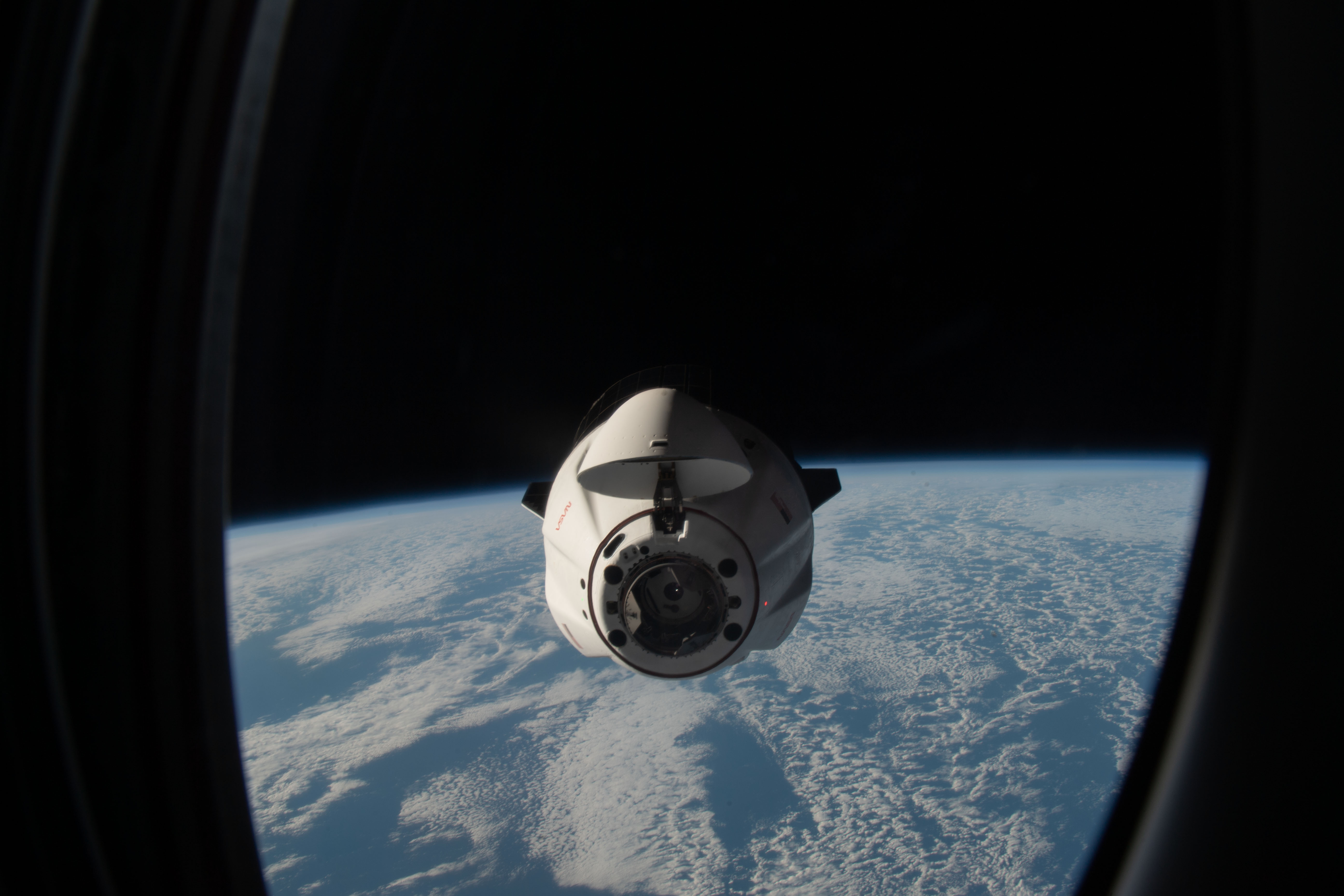 The SpaceX Dragon resupply ship carrying over 5,800 pounds of new science experiments and crew supplies, pictured from a window on the SpaceX Dragon Freedom crew ship, approaches the International Space Station above the south Atlantic Ocean.