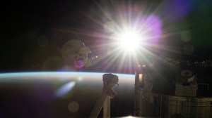 The SpaceX Dragon resupply ship, packed with over 4,000 pounds of return cargo and science experiments for analysis, backs away from the International Space Station moments after undocking from the Harmony module's forward port. The station was soaring into an orbital sunrise 260 miles above Hawaii's big island in the Pacific Ocean at the time of this photograph.