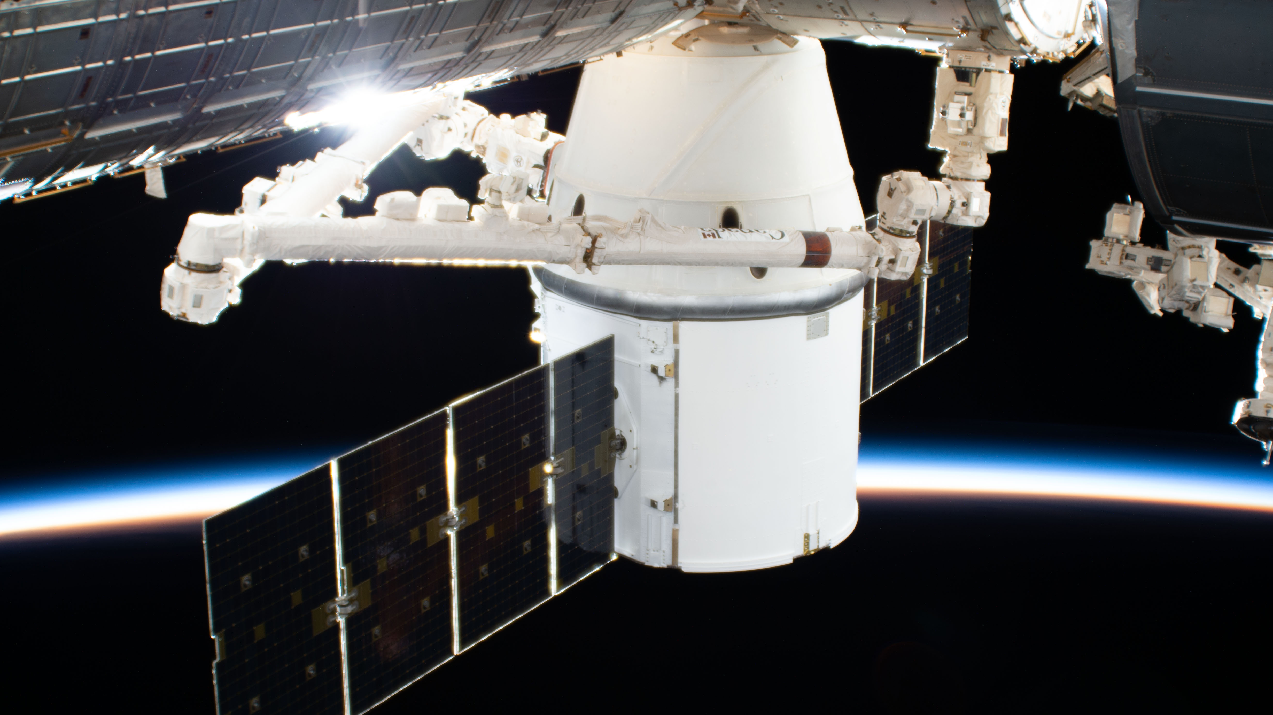 The SpaceX Dragon resupply ship is pictured in the grip of the Canadarm2 robotic arm after it was installed to the Harmony module. The International Space Station was orbiting 270 miles above the South Atlantic Ocean during an orbital sunset when this photograph was taken by an external high definition camera.