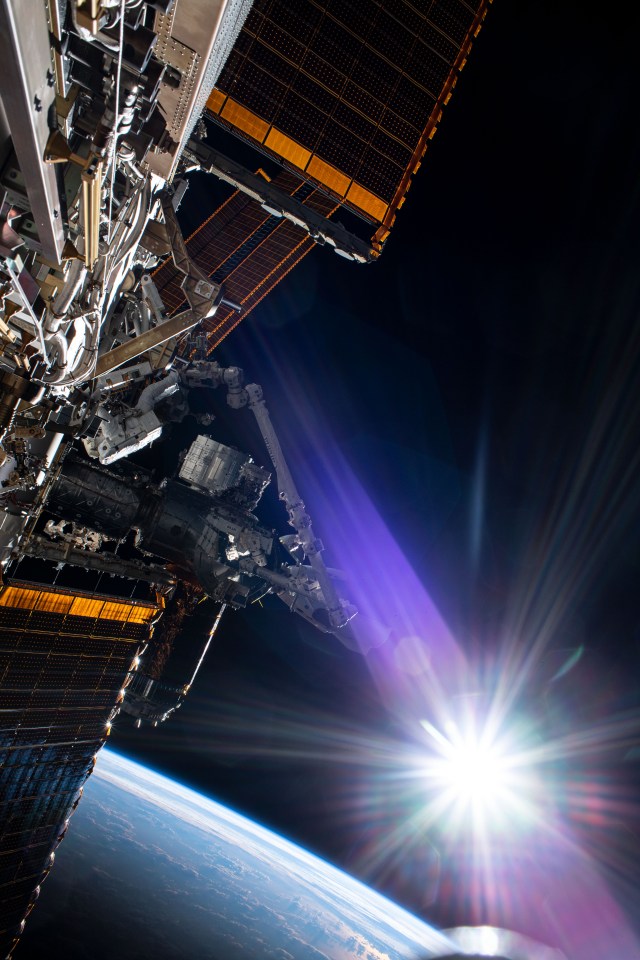 The sun beams just above the Earth's horizon as NASA astronaut and Expedition 63 Commander Chris Cassidy (center left) conducts his fourth spacewalk this year at the International Space Station. Cassidy has completed 10 spacewalks throughout his career for a total of 54 hours and 51 minutes spacewalking time.