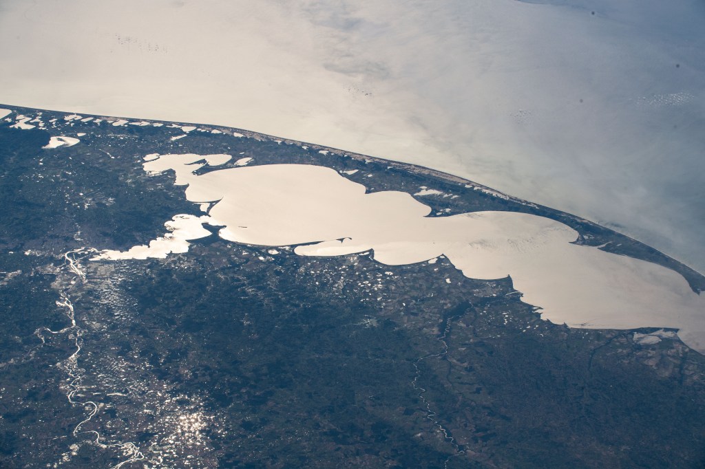 The Sun's glint beaming off Brazil's largest lagoon, Lagos dos Patos, on the nation's southernmost tip is pictured from an altitude of 260 miles as the International Space Station orbited across the South American continent's Atlantic coast.