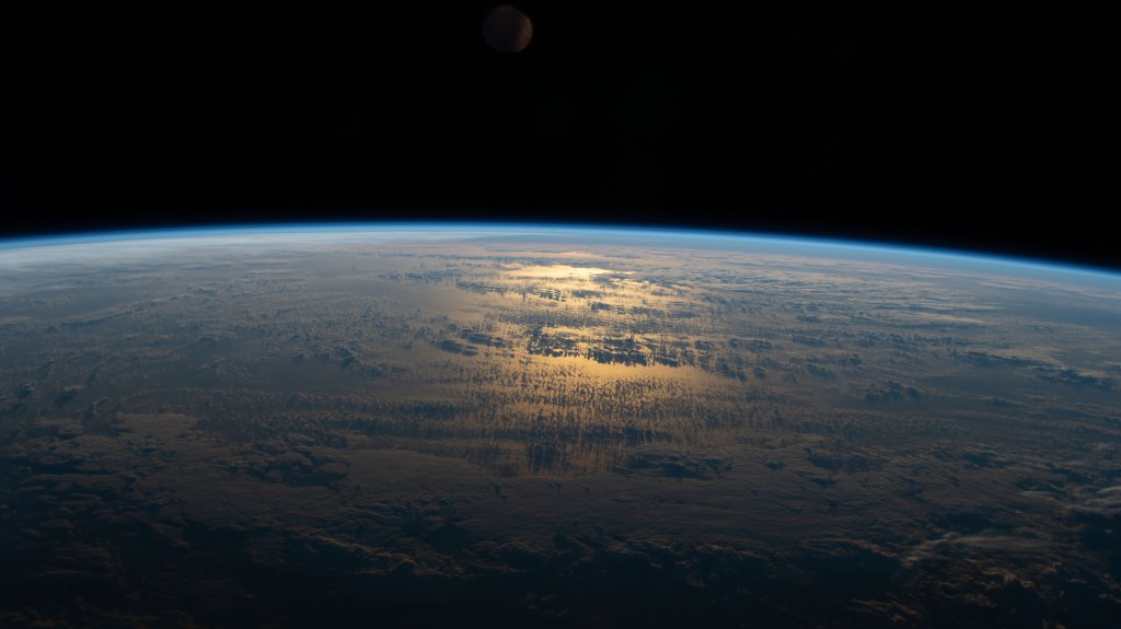 iss063e050668 (July 18, 2020) --- The sun's glint beams off a partly cloudy South Pacific as the International Space Station's orbital track took it halfway between Australia and South America.