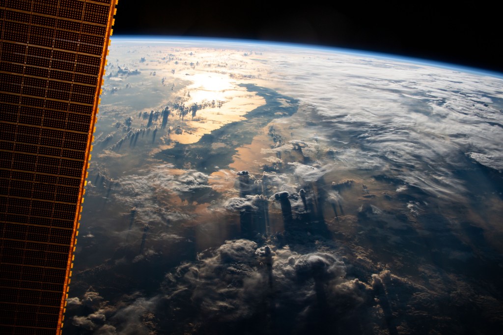 The International Space Station flies 255 miles above Indonesia as the sun's glint beams off the Celebes Sea in southeast Asia.