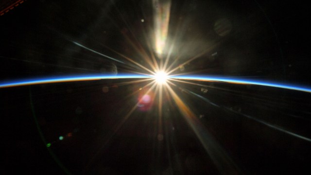 The sun's rays begin to illuminate the Earth's atmosphere as the International Space Station flew into an orbital sunrise 261 miles above Texas.