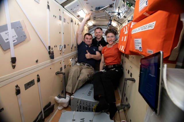 The three crewmates who rode the Soyuz MS-12 spacecraft to the International Space Station gather inside the Rassvet module after conducting a periodic routine emergency drill. From left are, Soyuz Commander Alexey Ovchinin of Roscosmos and NASA Flight Engineers Nick Hague and Christina Koch.