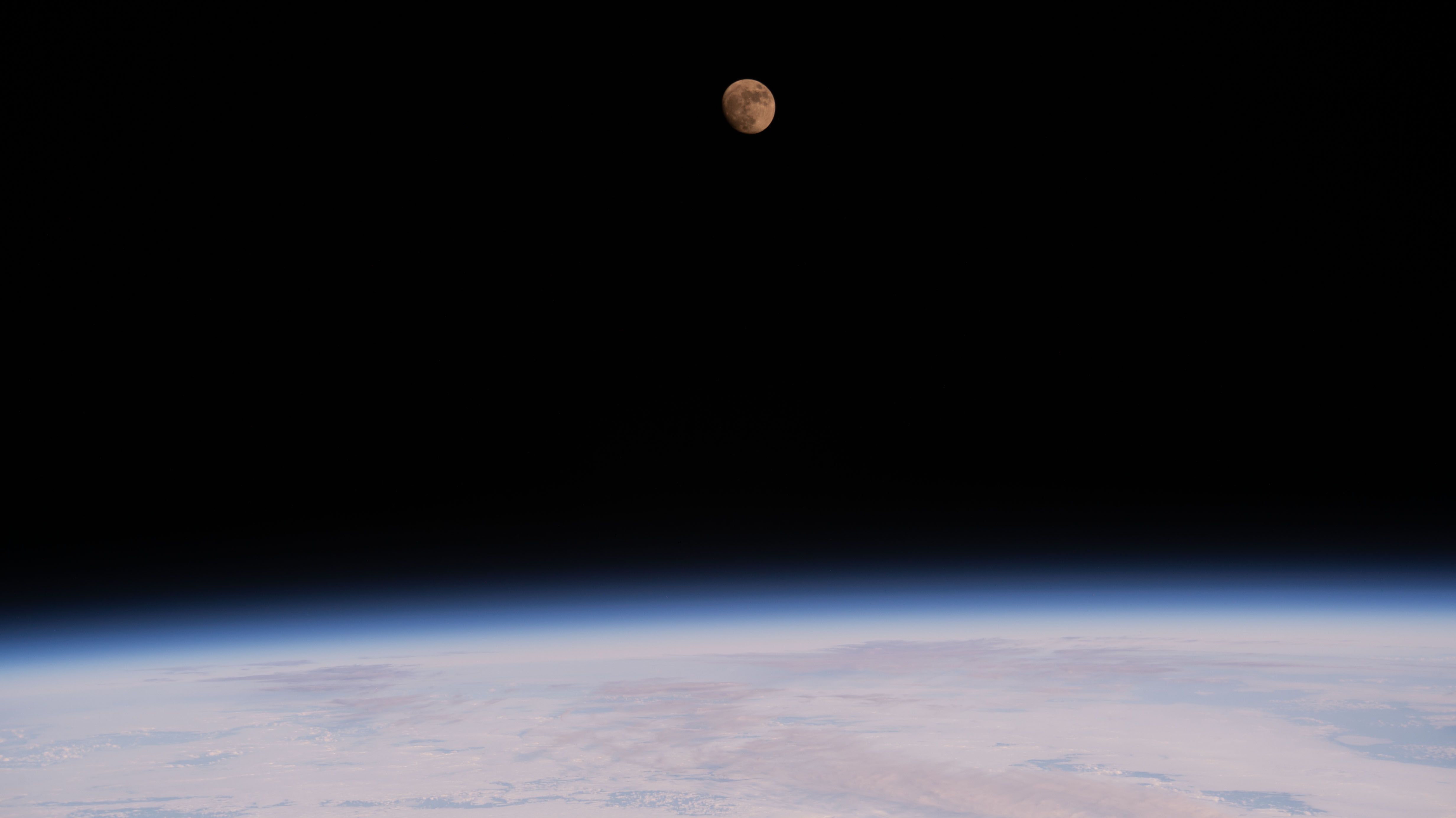 The waxing gibbous Moon is pictured above the Earth's horizon from the International Space Station as it orbited 259 miles above the northern Pacific Ocean.