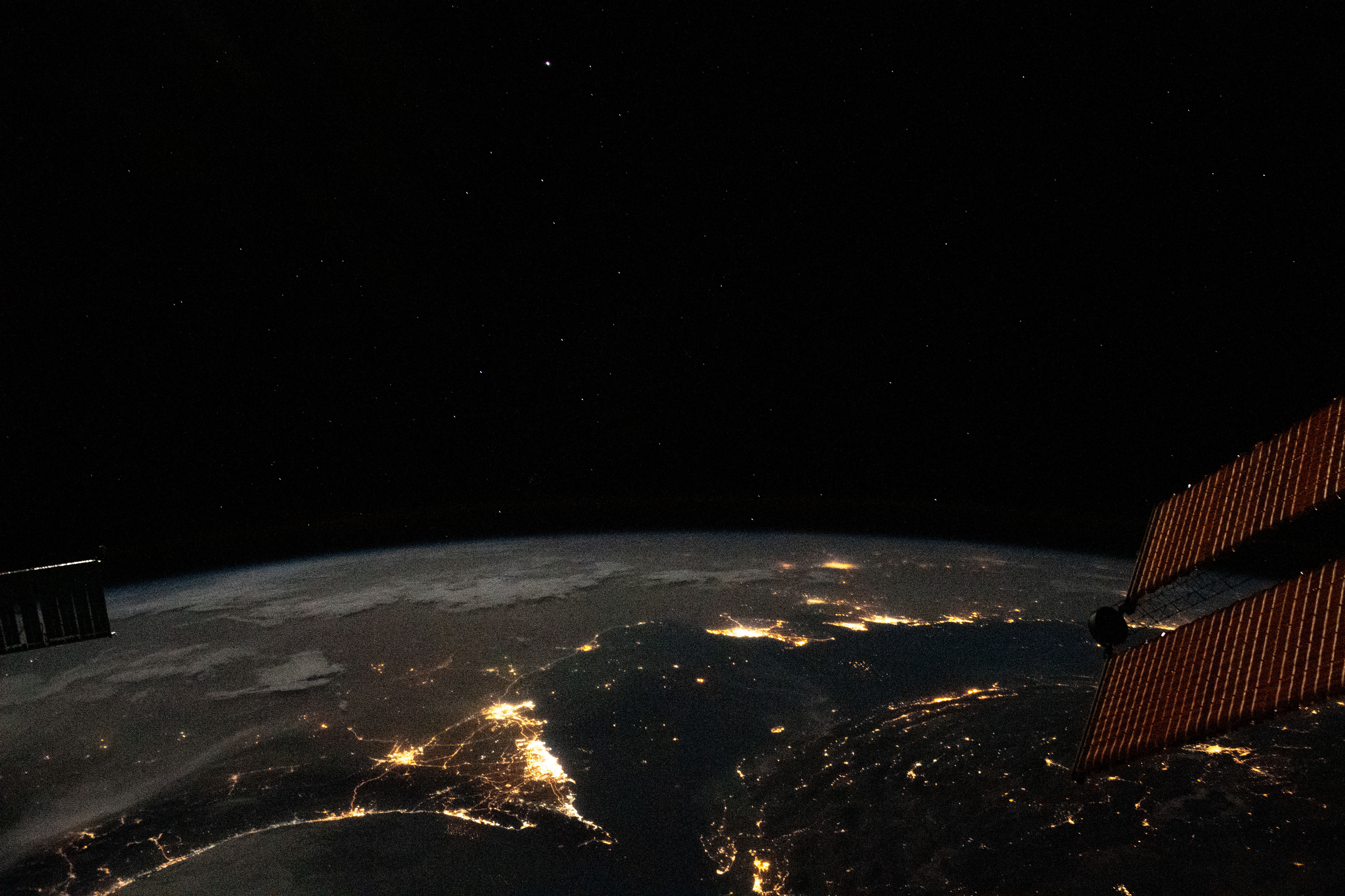 Photographed from the International Space Station at night, the well-lit United Arab Emirates (lower center) is situated at the northeast end of the Arabian Peninsula, with Qatar and Bahrain to the north on the coast of the Persian Gulf.