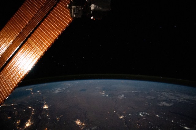 This nighttime photograph from the International Space Station looks north across Turkmenistan and Uzbekistan with the Caspian Sea at left towards the Earth's horizon. At bottom left, is the populated oasis area of Turkmenistan near the border with Iran.