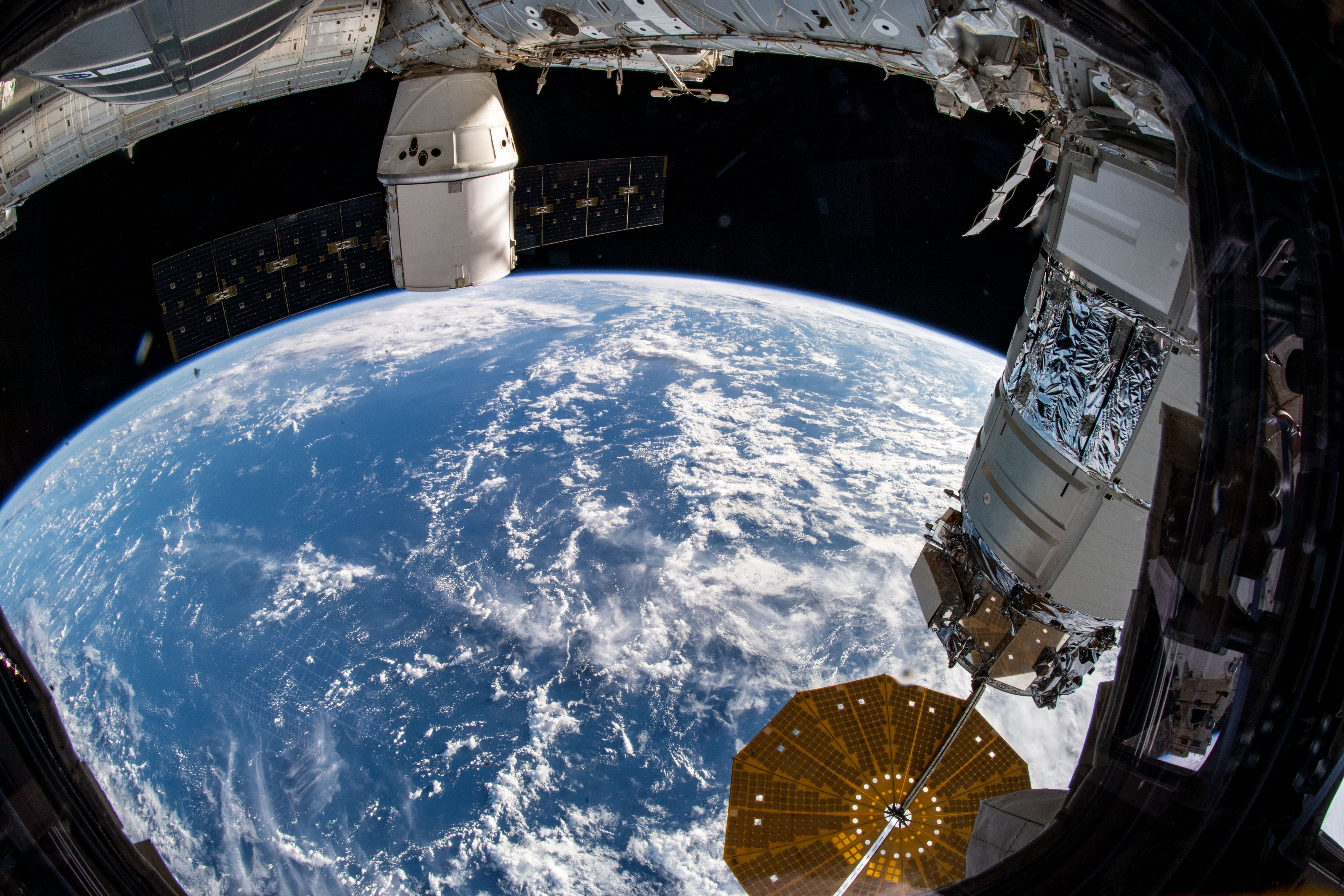Two U.S. cargo ships are pictured attached to the International Space Station as the orbital complex flew 260 miles above the Laccadive Sea south of India. In the right foreground, the Northrop Grumman Cygnus space freighter, with one of its prominent cymbal-shaped UltraFlex solar arrays below, is attached to the Unity module. At top rear, the SpaceX Dragon commercial resupply ship is attached to the Harmony module.