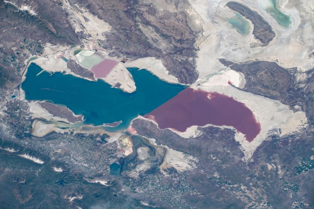 Utah's Great Salt Lake is pictured as the International Space Station orbited 255 miles above the southwestern United States. The distinct color differences in the lake is caused by a railroad causeway. The northern part of the lake (pointing right in this frame) has a much higher salinity than the southern freshwater portion of the lake.