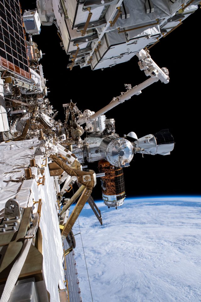 This view of the International Space Station's U.S. forward segment shows the SpaceX Crew Dragon vehicle (right center) docked to the Harmony module's International Docking Adapter. Adjacent to the Crew Dragon is the H-II Transfer Vehicle-9 (HTV-9) from the Japan Aerospace Exploration Agency attached to the Harmony module's Earth-facing port.