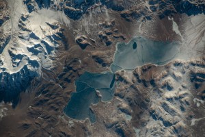iss070e088503 (Feb. 8, 2024) -- A duo of Tibetan lakes, Qingche and Luotuo, are covered with ice as snow drifts through the mountainous terrain. The International Space Station was orbiting 260 miles above when NASA astronaut Jasmin Moghbeli captured this image.