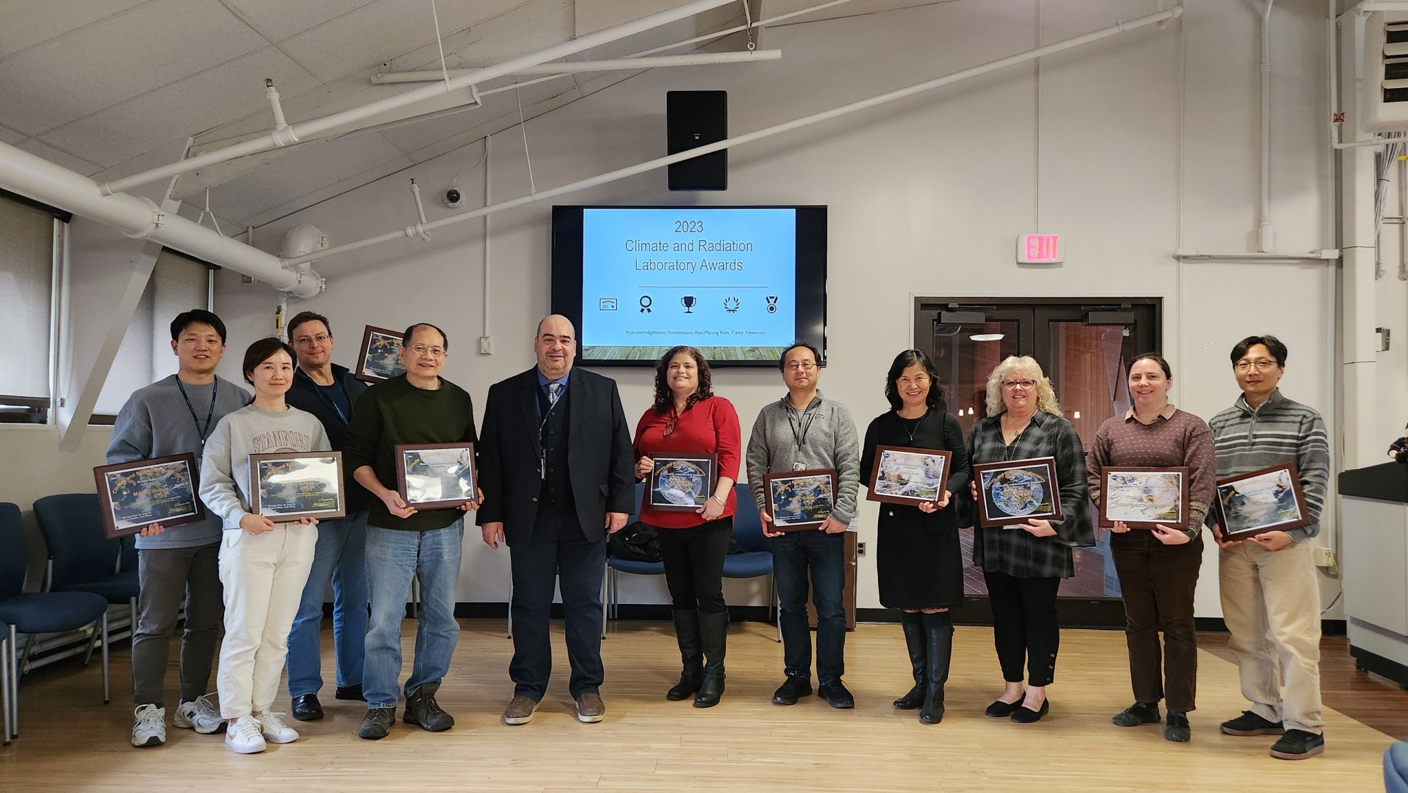 A group of people holding awards stand side by side in front of a screen that says "2023 Climate and Radiation Laboratory Awards"