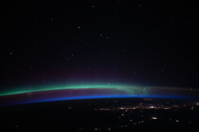 iss062e098273 (March 16, 2020) --- An aurora, above the city lights and a beneath a starry sky, fades into an orbital sunrise as the International Space Station orbited 263 miles above the Pacific Ocean off the coast of North America.
