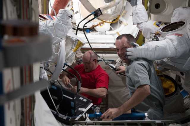 Astronauts Scott Tingle (left) and Ricky Arnold wrap up spacesuit work following a successful spacewalk on March 29, 2018. The duo scrubbed cooling loops, performed the iodination of ion filters and tested the water conductivity inside a pair of U.S. spacesuits.