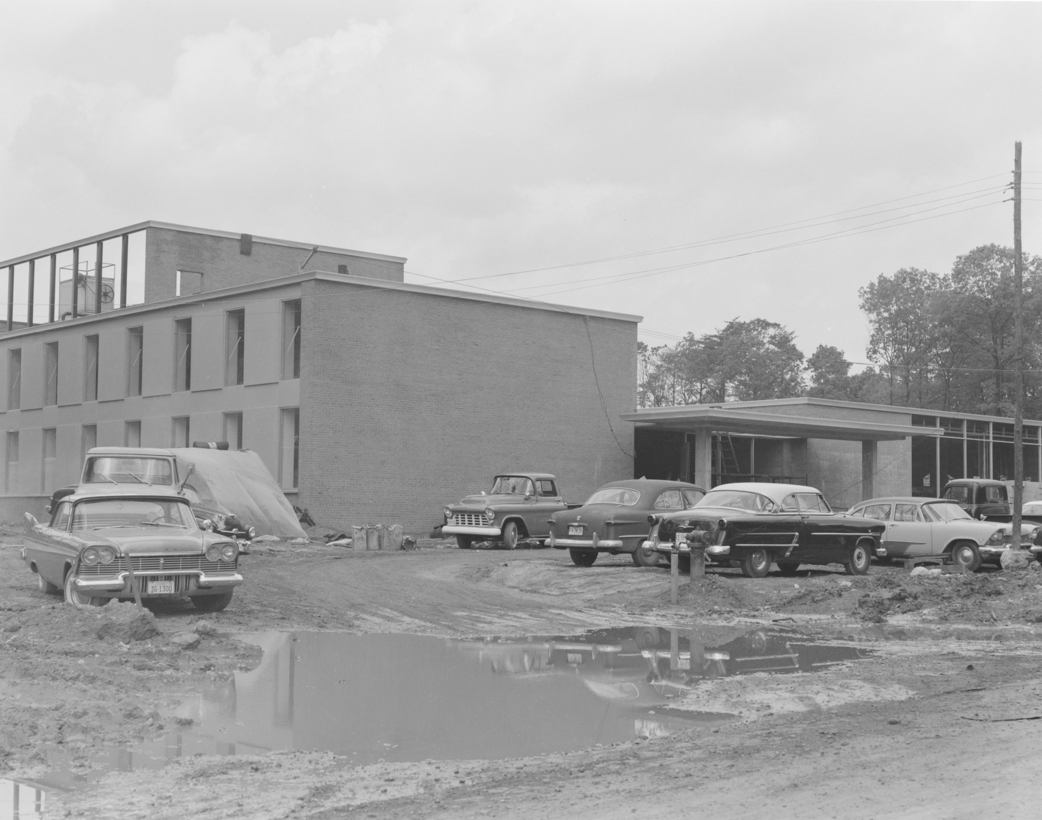 Cars parked outside NASA Goddard's Building 1 in a muddy lot