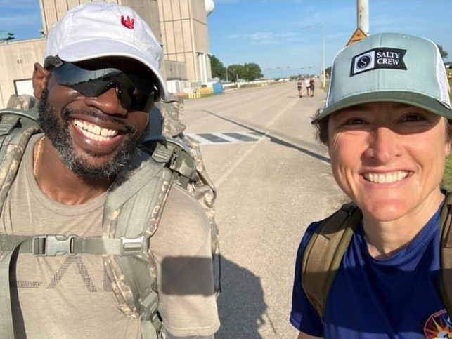 Corey Twine wearing a backpack standing next to  astronaut CHristin Koch