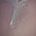 Satellite image of another spacecraft above a red, sandy landscape.