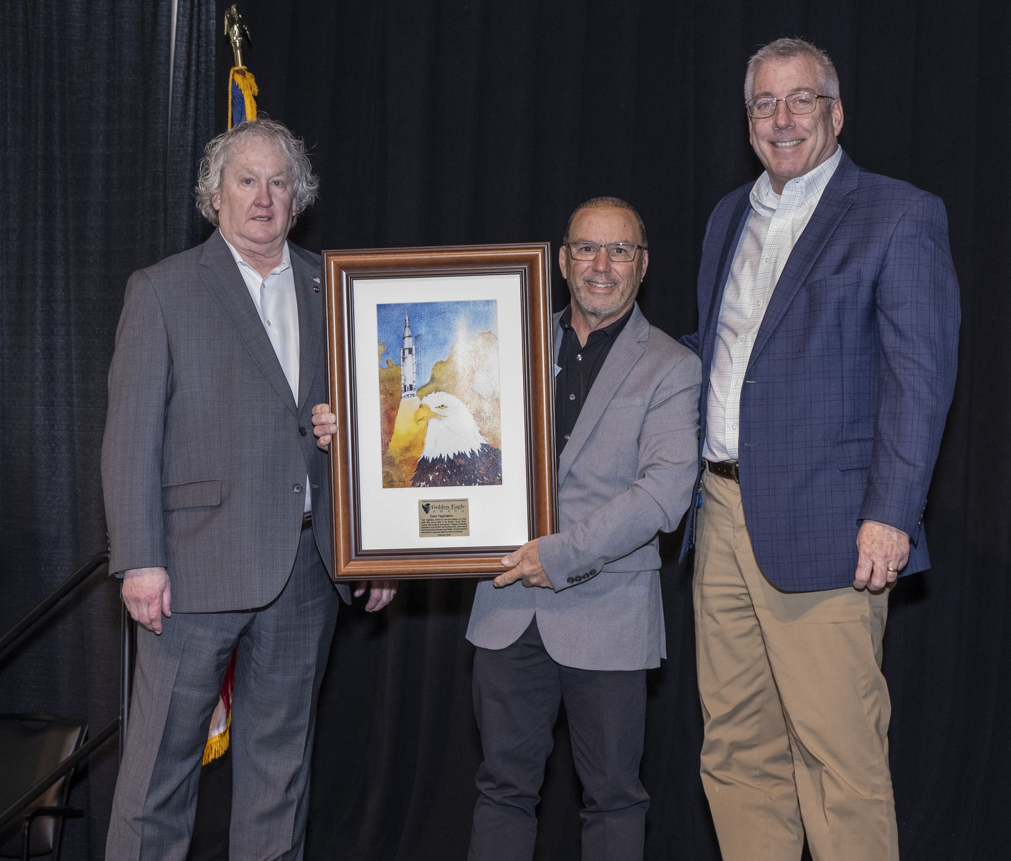 Tag Taglilatelo, center, of Jacobs Space Exploration Group, displays the Golden Eagle Award that was presented to him during the Mission Success is in Our Hands forum. He is joined by Bill Hill, left, director of Safety and Mission Assurance at Marshall, and Jeff Haars, Jacobs vice president and program manager for Jacobs Space Exploration Group.