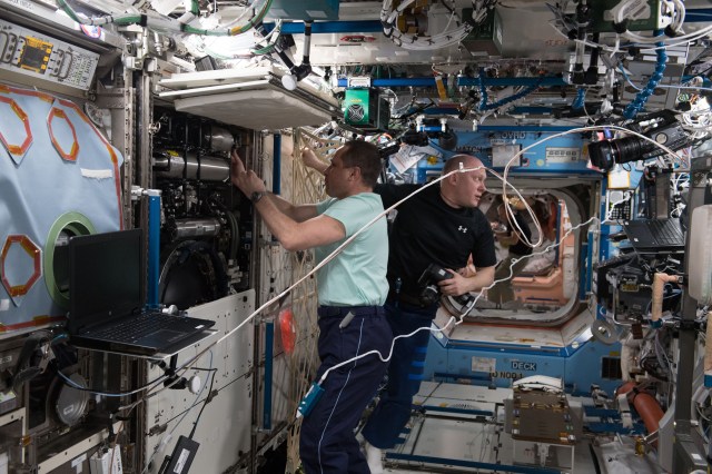 Expedition 55 Commander Anton Shkaplerov (foreground) and Flight Engineer Oleg Artemyev, both cosmonauts representing Roscosmos, replace manifold bottles inside the the Destiny lab module's Combustion Integrated Rack.