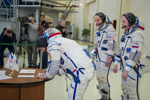 At the Gagarin Cosmonaut Training Center in Star City, Russia, Expedition 55 crew member Drew Feustel of NASA (left) signs in Feb. 21 for the final day of crew qualification exams. Looking on are crewmates Ricky Arnold of NASA (center) and Oleg Artemyev of Roscosmos (right). They will launch March 21 from the Baikonur Cosmodrome in Kazakhstan on the Soyuz MS-08 spacecraft for a five-month mission on the International Space Station.