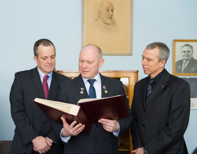 In the museum at the Gagarin Cosmonaut Training Center in Star City, Russia, Expedition 55 crew members Ricky Arnold of NASA (left), Oleg Artemyev of Roscosmos (center) and Drew Feustel of NASA (right) check out a ceremonial book signed by all astronauts and cosmonauts who fly in space during traditional pre-launch activities Feb. 22. They will launch March 21 on the Soyuz MS-08 spacecraft from the Baikonur Cosmodrome in Kazakhstan for a five-month mission on the International Space Station.