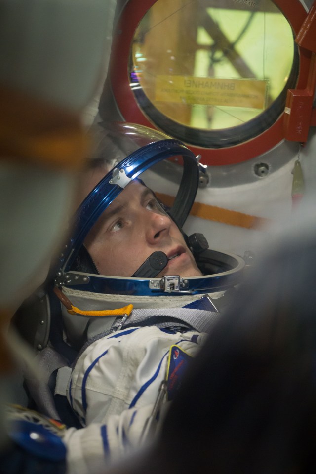 At the Baikonur Cosmodrome in Kazakhstan, Expedition 57 crew member Nick Hague is seen through a window on the Soyuz MS-10 spacecraft as he conducted a fit check dress rehearsal Sept. 26. Hague and Alexey Ovchinin of Roscosmos will launch Oct. 11 in the Soyuz MS-10 from the Baikonur Cosmodrome for a six-month mission on the International Space Station.