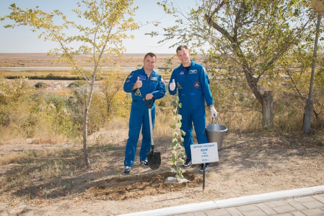 Expedition 57 crew members Alexey Ovchinin of Roscosmos, left, and Nick Hague of NASA, right, pose for a picture after Hague planted a tree bearing his name as part of the traditional pre-launch activities for first-time flieers, Wednesday, Oct. 3, 2018 at the Cosmonaut Hotel in Baikonur, Kazakhstan. Hague and Ovchinin are scheduled to launch on Oct. 11 onboard the Soyuz MS-10 spacecraft from the Baikonur Cosmodrome in Kazakhstan for a six-month mission on the International Space Station.