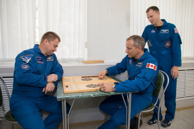 Expedition 57 prime crew member Alexey Ovchinin of Roscosmos, left, plays backgammon with backup crew member David Saint-Jacques of the Canadian Space Agency as prime crew member Nick Hague of NASA looks on during the traditional pre-launch ceremonies, Wednesday, Oct. 3, 2018 at the Cosmonaut Hotel in Baikonur, Kazakhstan. Ovchinin and Hague are scheduled to launch on Oct. 11 onboard the Soyuz MS-10 spacecraft from the Baikonur Cosmodrome in Kazakhstan for a six-month mission on the International Space Station.