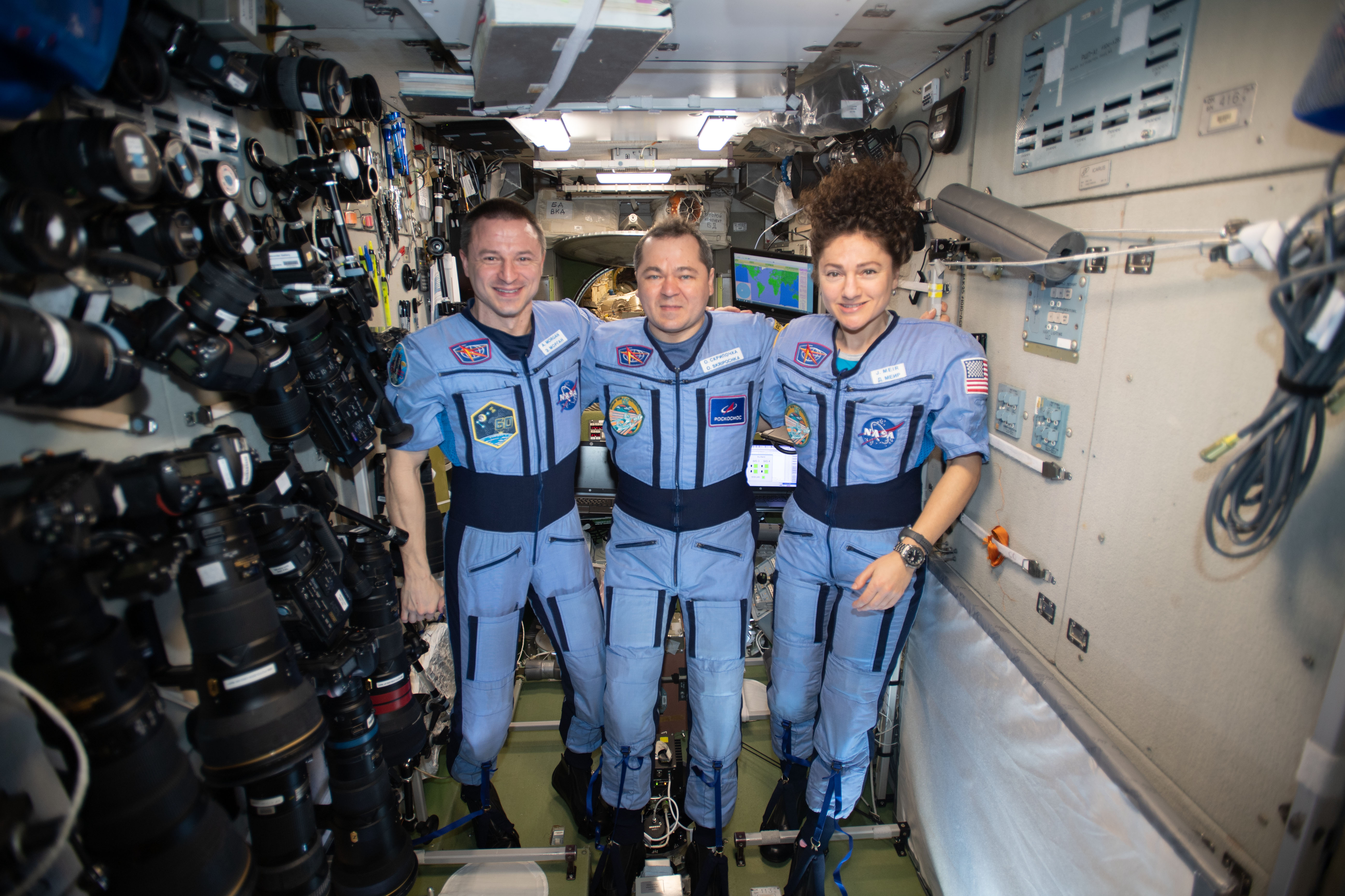 iss062e116035 (March 29, 2020) --- NASA Flight Engineers Andrew Morgan and Jessica Meir flank Expedition 62 Commander Oleg Skripochka of Roscosmos for a portrait in the weightless environment of the International Space Station.
