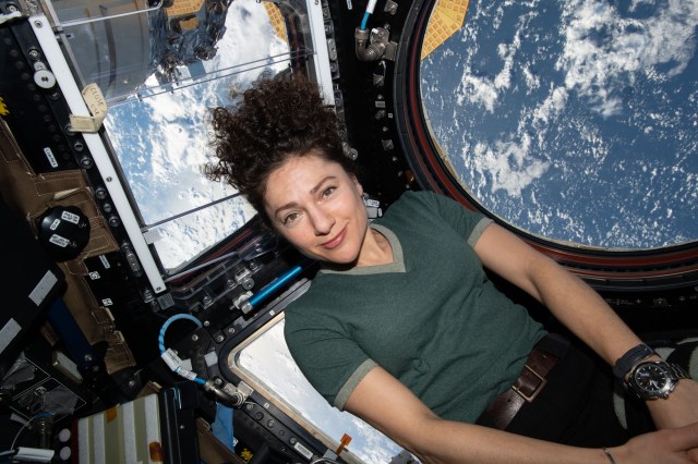 iss062e148377 (April 12, 2020) --- NASA astronaut and Expedition 62 Flight Engineer Jessica Meir poses for a portrait inside the International Space Station's "window to the world," the cupola. The orbiting lab was flying above the middle of the Pacific Ocean at the time this photograph was taken.