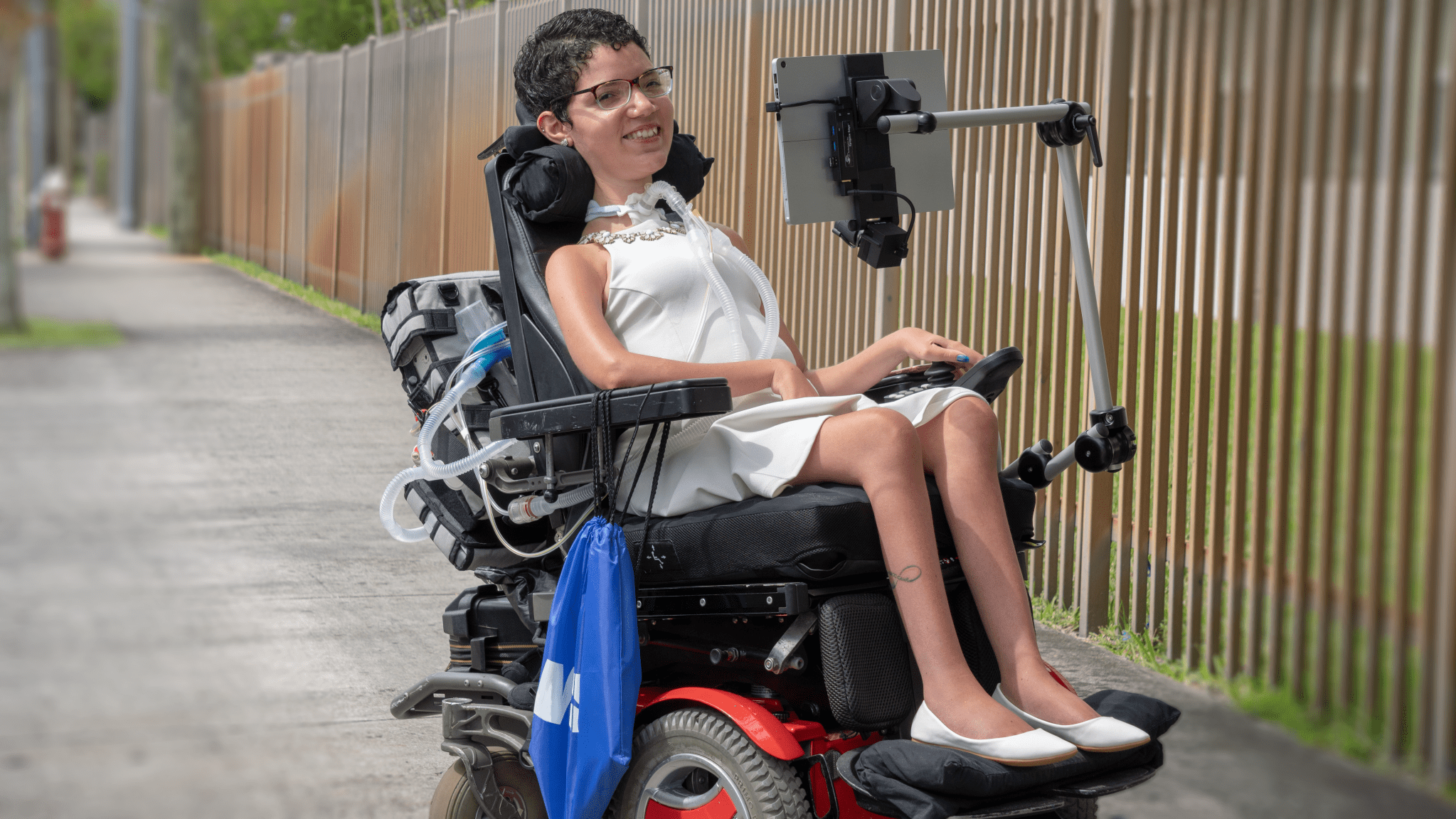 Girl in a wheelchair with a laptop display on a mount