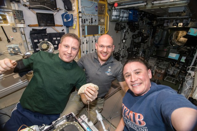 Flight Engineer Serena Auñón-Chancellor (right) takes a group selfie with her Expedition 57 crew mates (from left) Flight Engineer Sergey Prokopyev and Commander Alexander Gerst. The three-person crew was gathered for dinner in the Zvezda Service Module, part of the International Space Station's Russian segment.