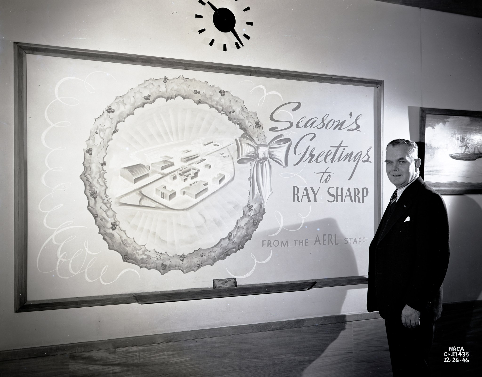 Man looking at holiday greeting on wall.