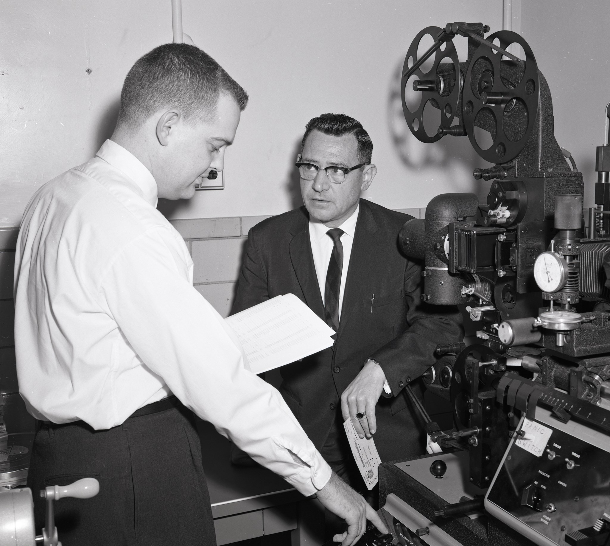 Two men operating projector.