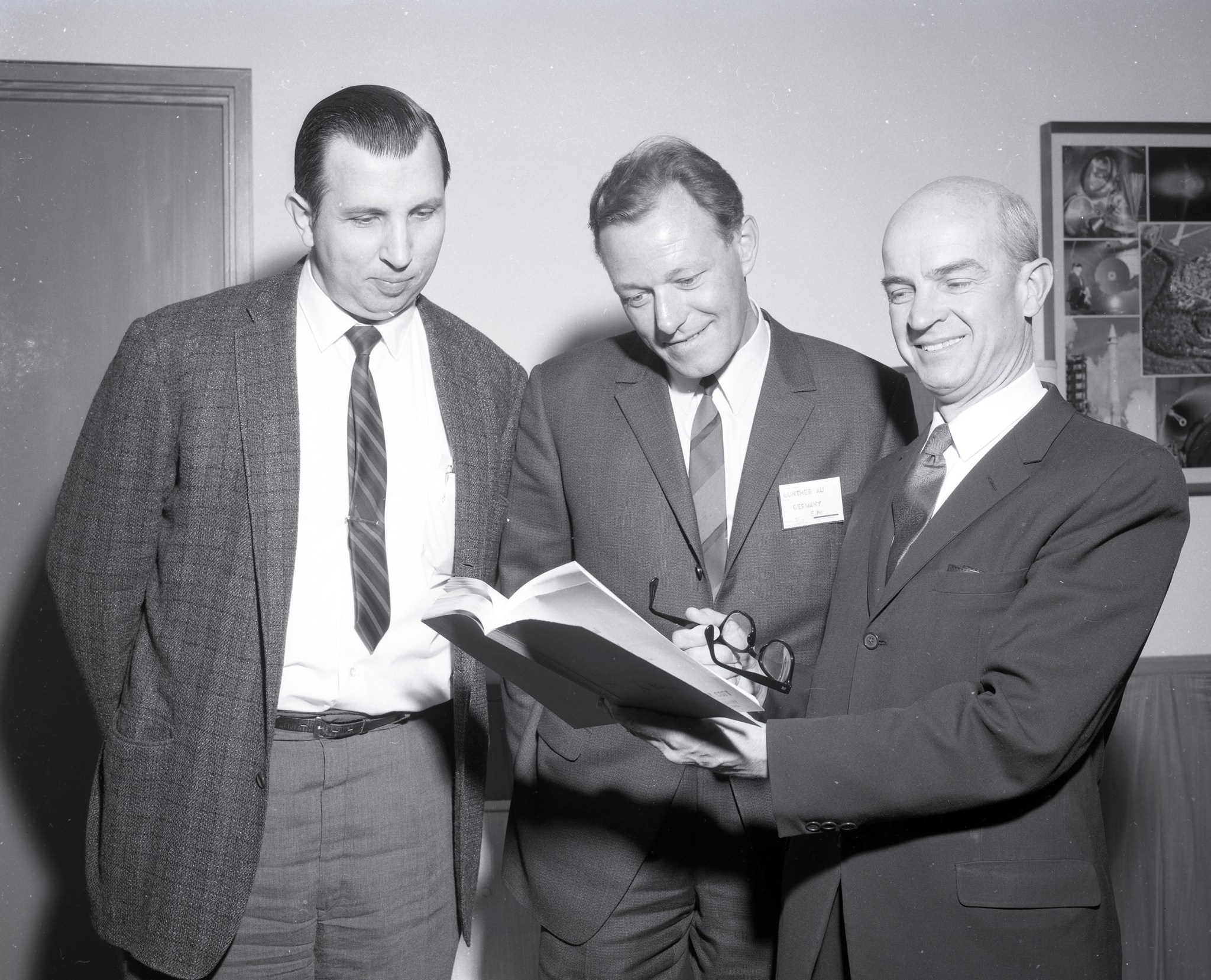 Three men reading book.