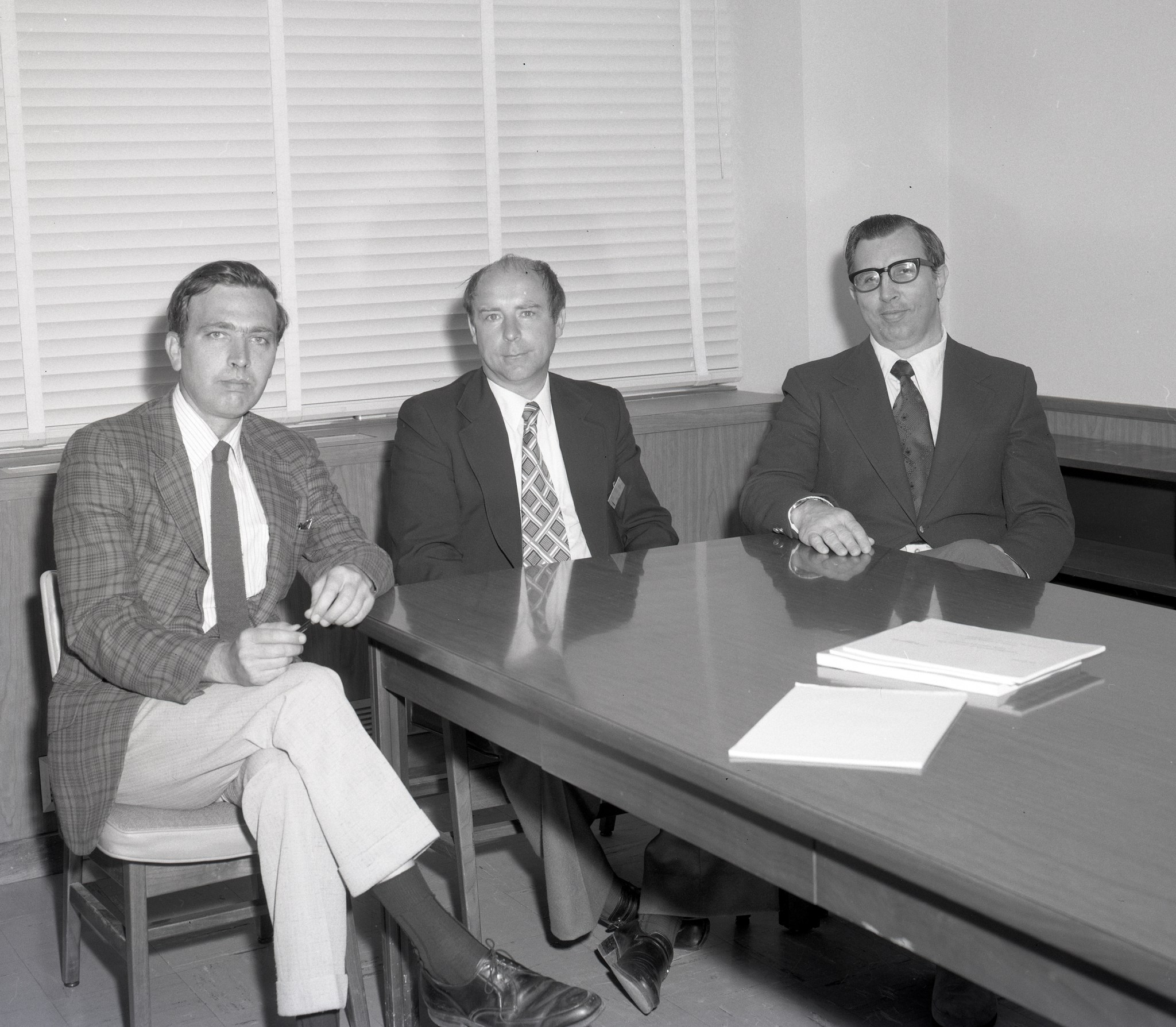 Three men seated at table.