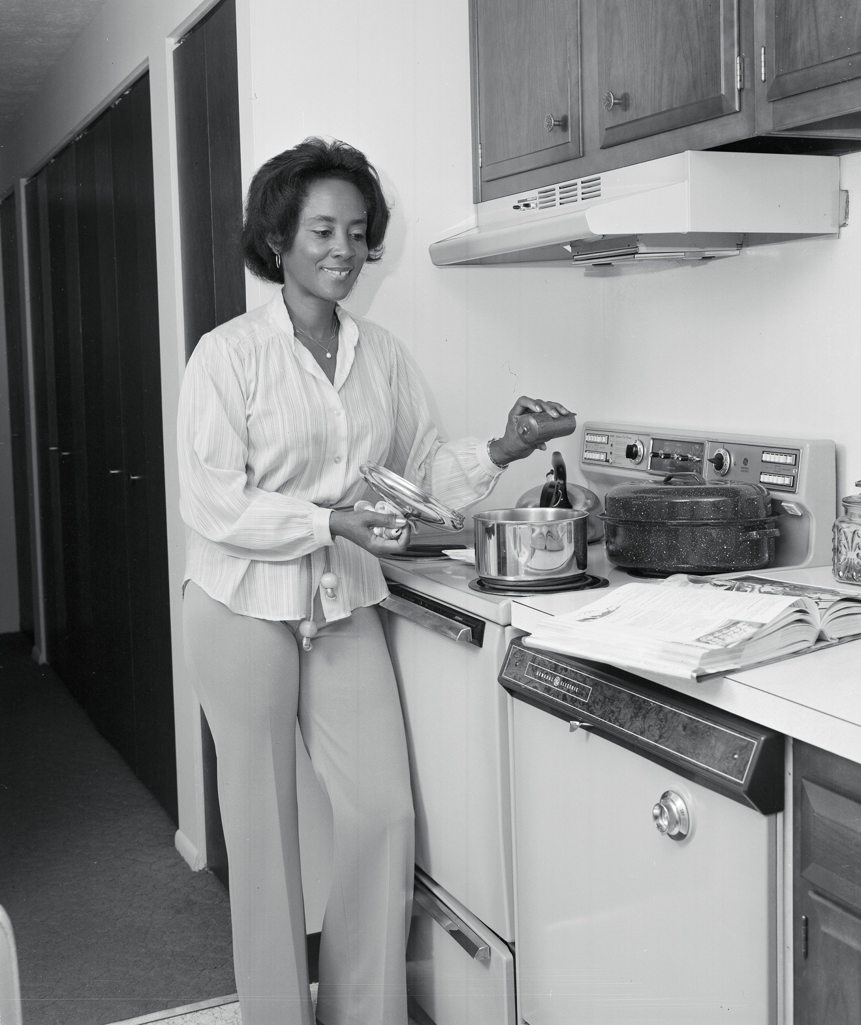 Woman standing by stove.