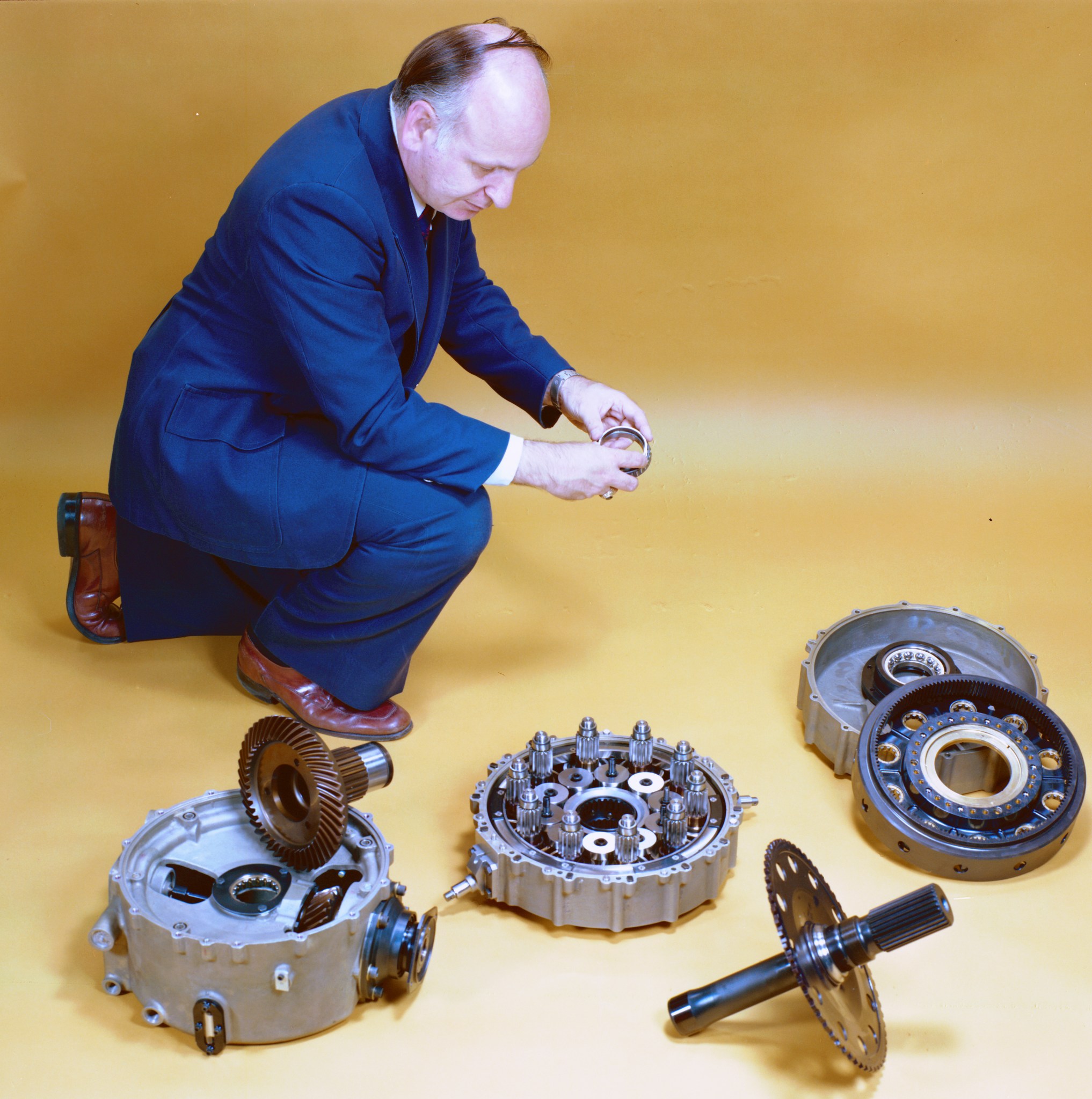 Man kneeling to look at rotor components.
