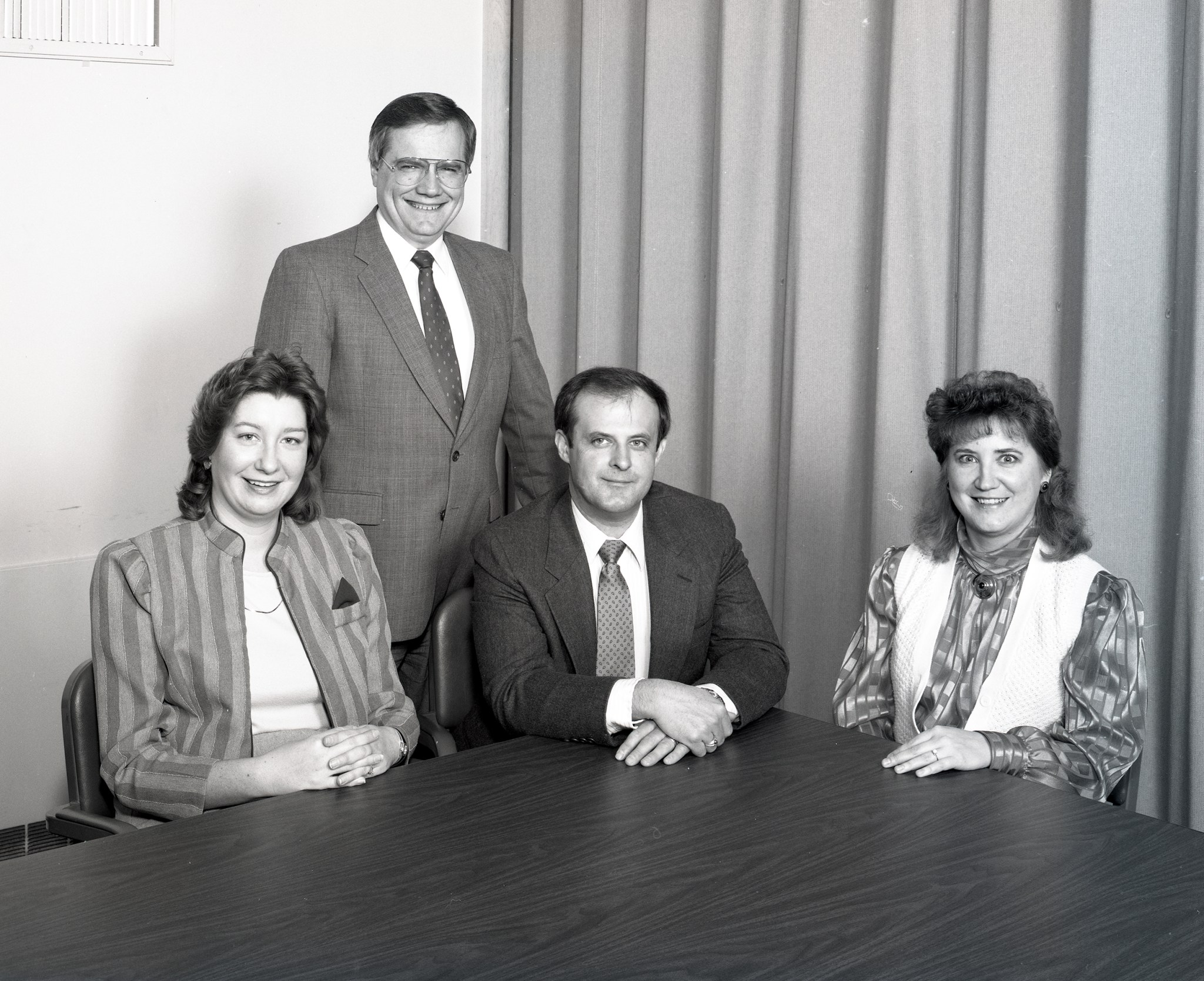 Four people posing for photograph.