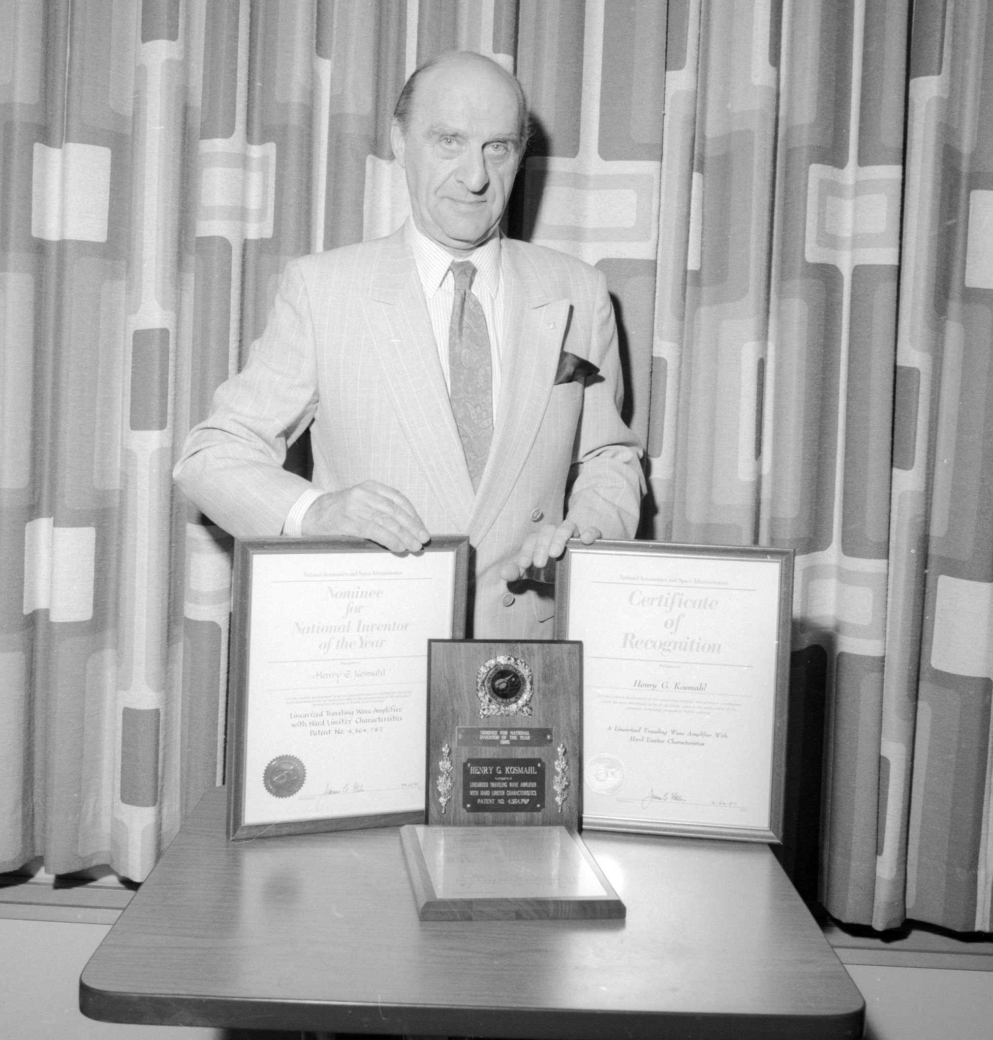 Man standing with two awards.