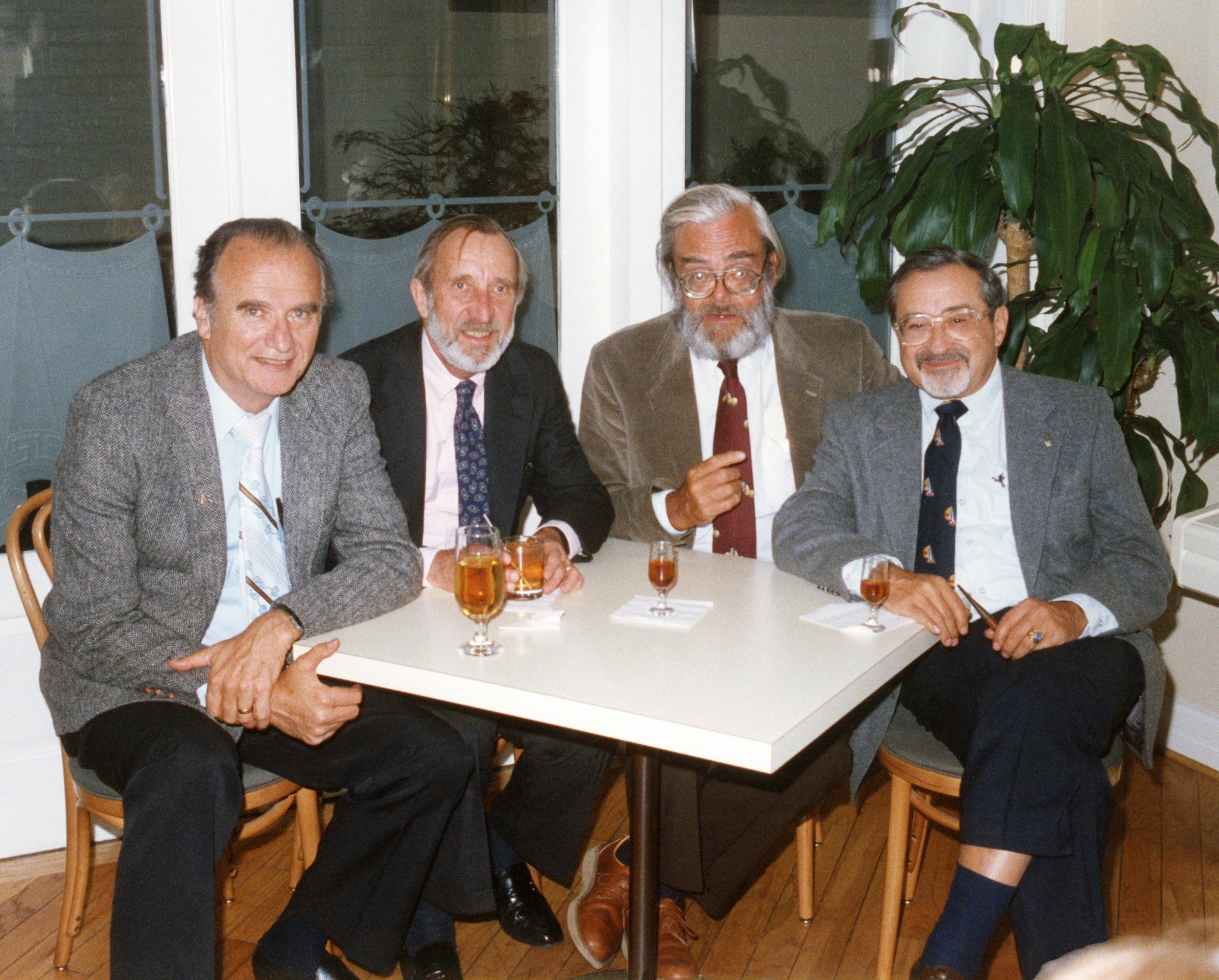 Four men seated at table.