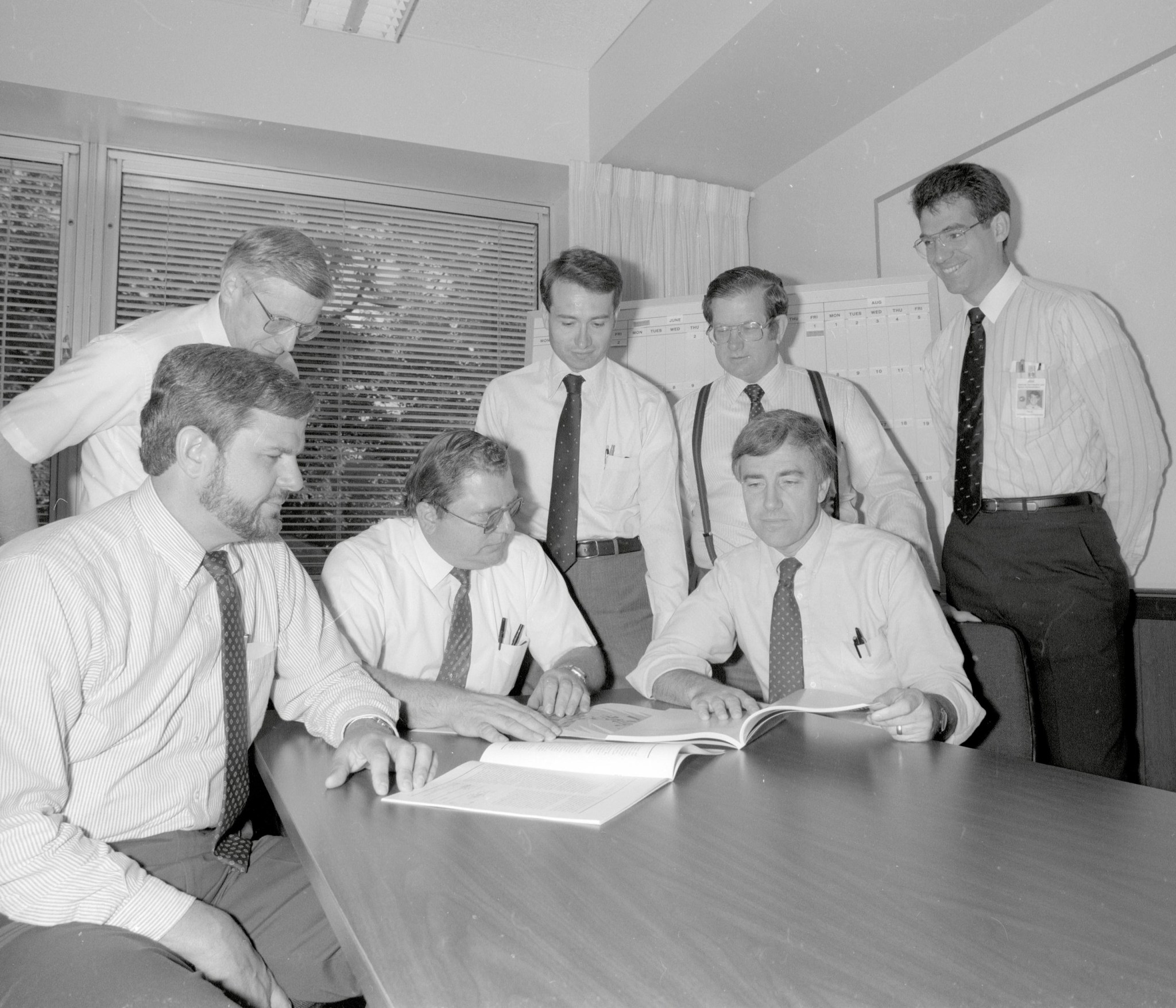Group of men at conference table.